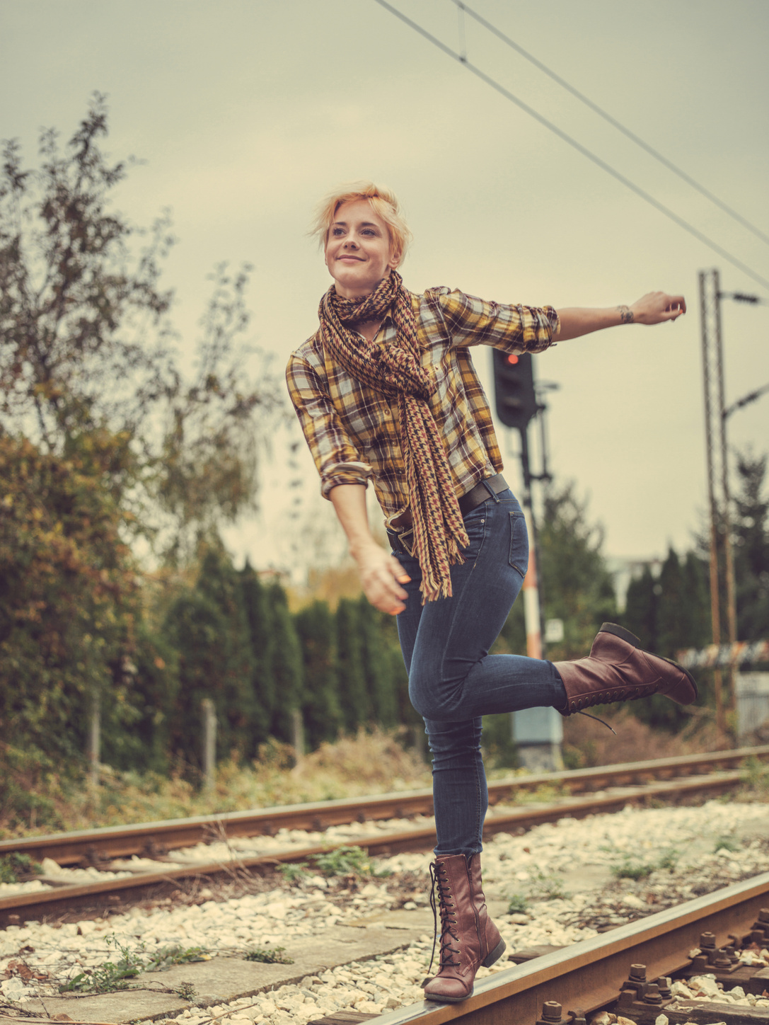 young woman walking on train tracks